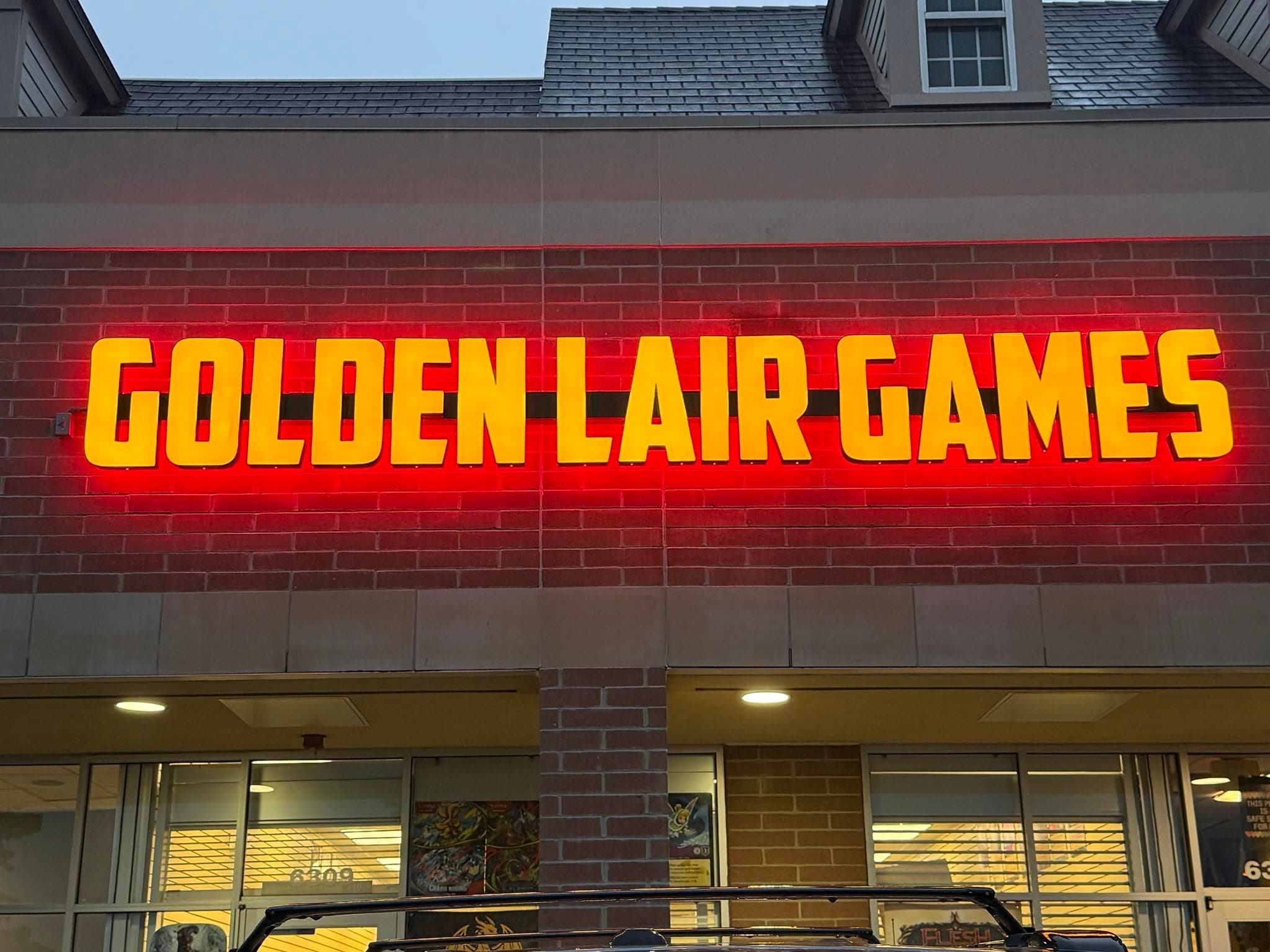 Golden Lair Games storefront sign at the Grand Blanc location